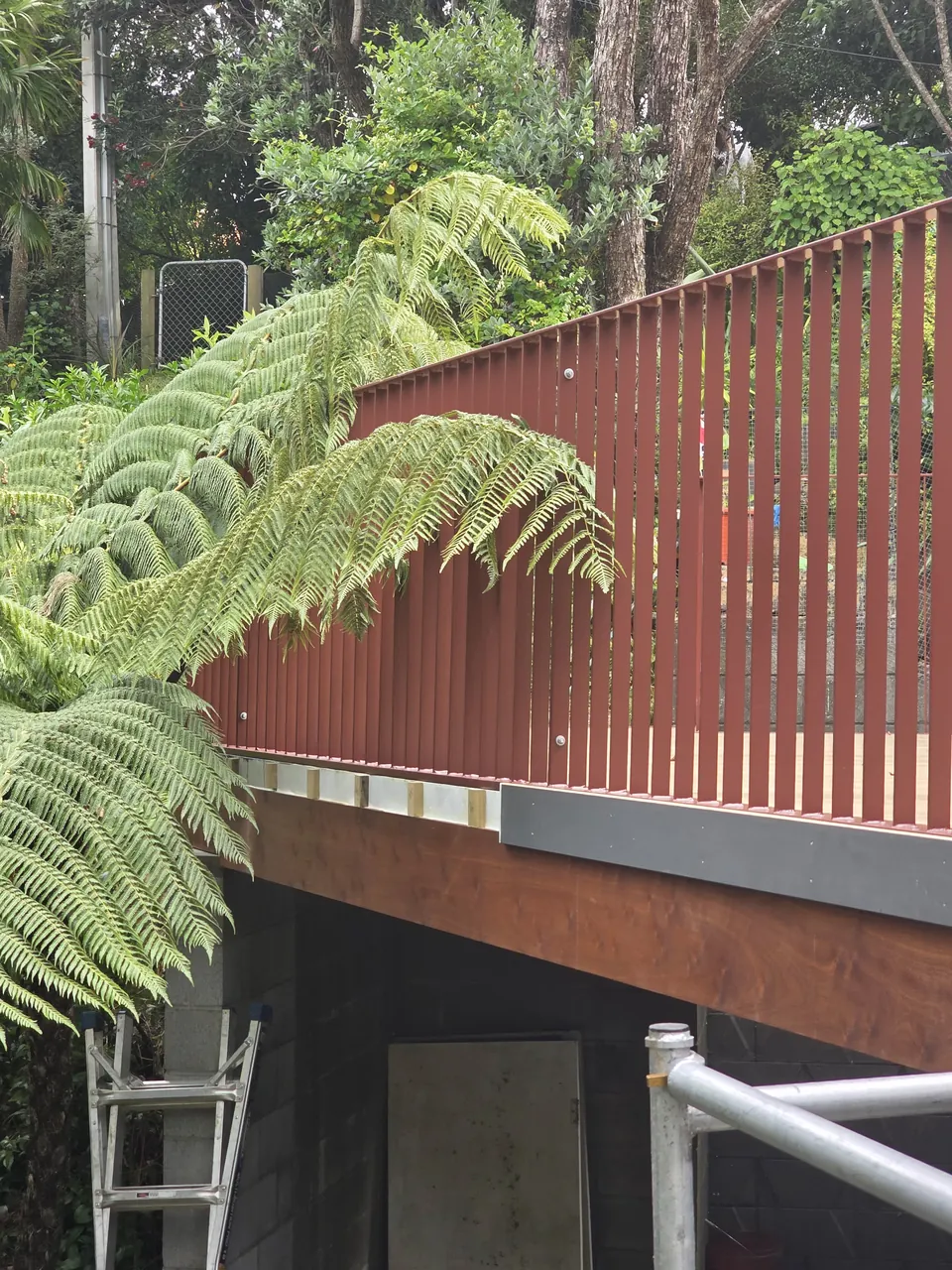 Vertical balustrade detailing beside tree ferns