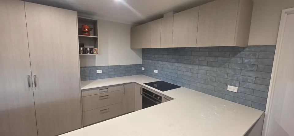 Kitchen cabinetry, tiled splashback and stone worktop